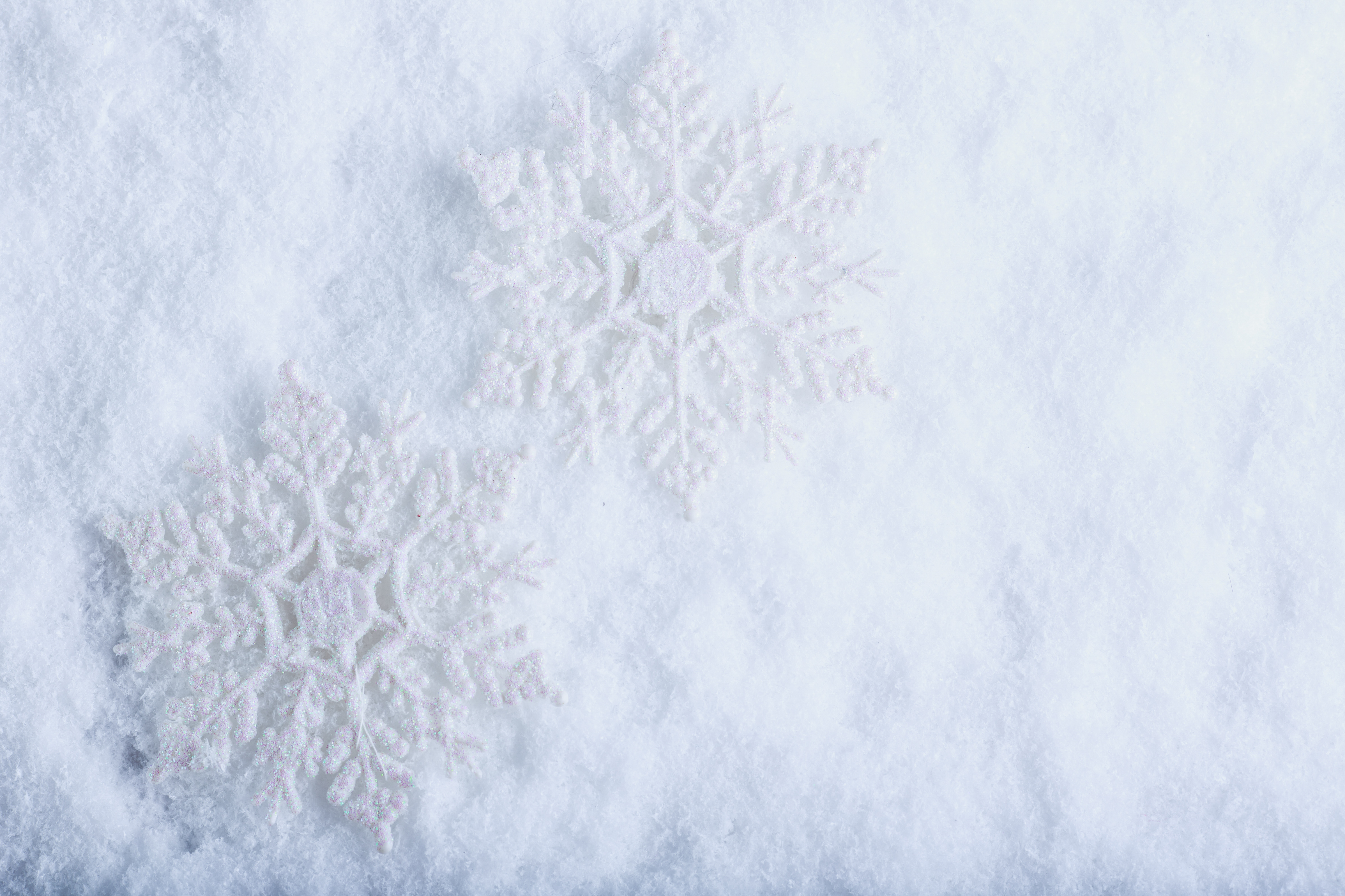 Two beautiful sparkling vintage snowflakes on a white frost snow
